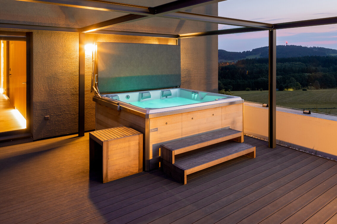 Premium USSPA Virgo iN hot tub with night lighting and wooden accents.