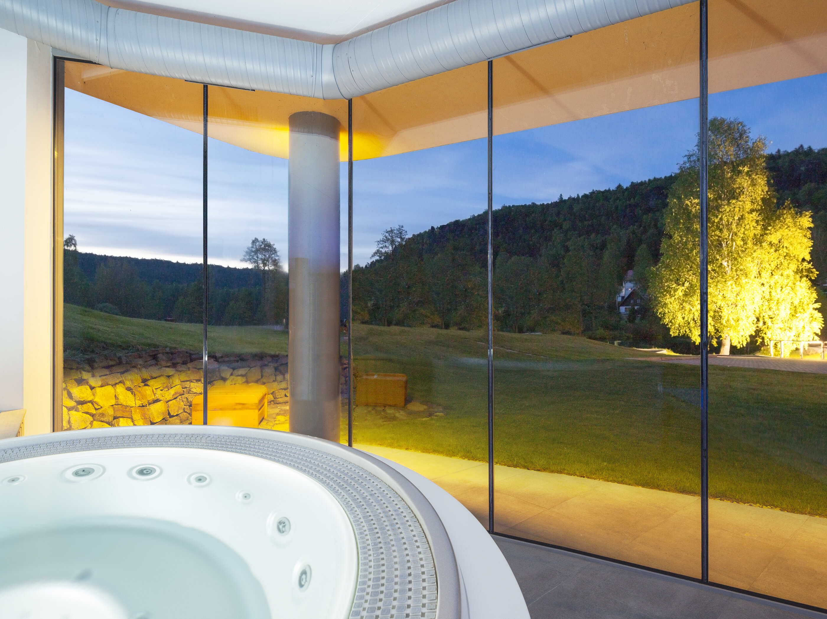 USSPA Polo – circular indoor wellness with ergonomic bench and jets overlooking a garden.