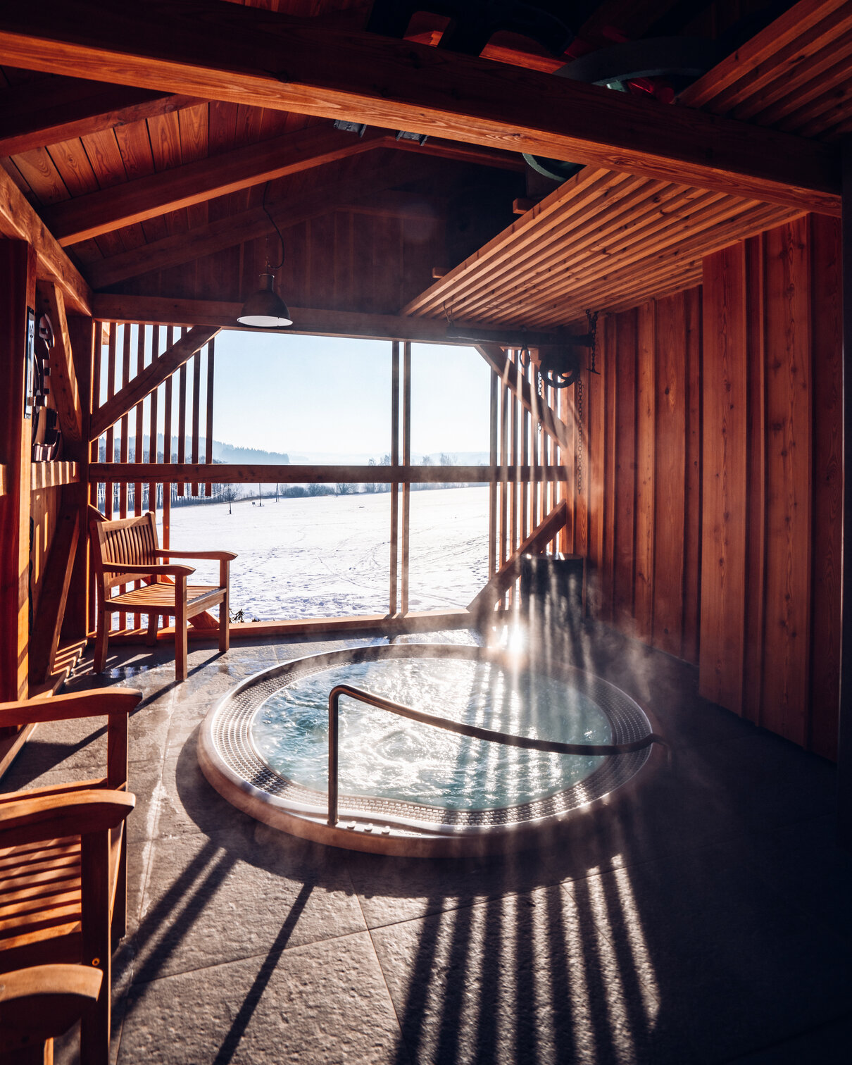 USSPA Polo – outdoor circular wellness with ergonomic bench and jets overlooking a snowy landscape.