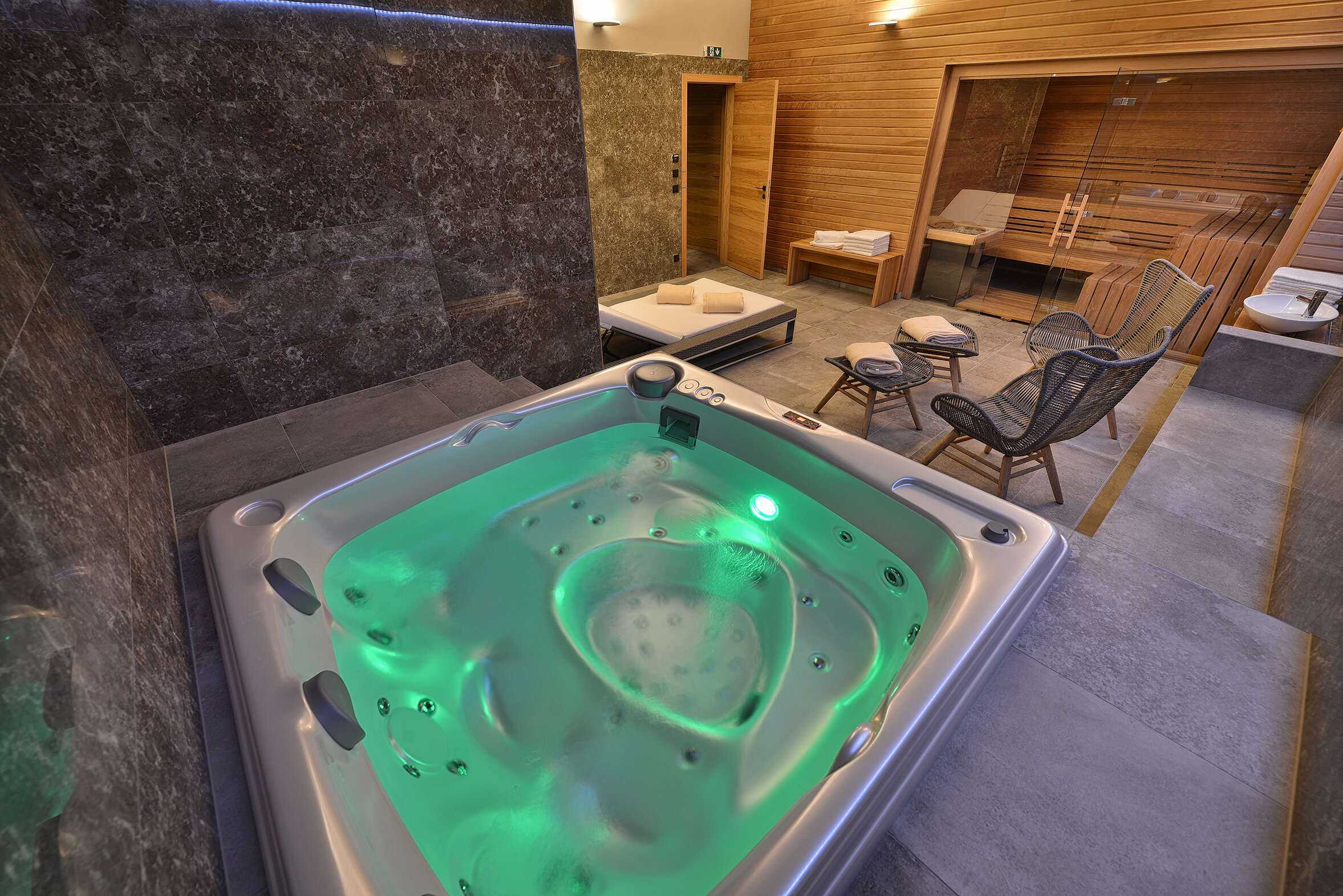 Indoor installation of the USSPA Aston hot tub in a home wellness area with a sauna.