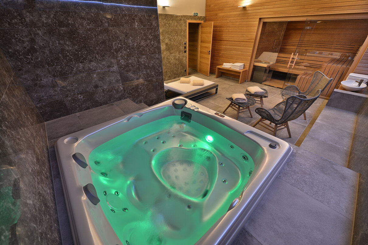 Indoor installation of the USSPA Aston hot tub in a home wellness area with a sauna.