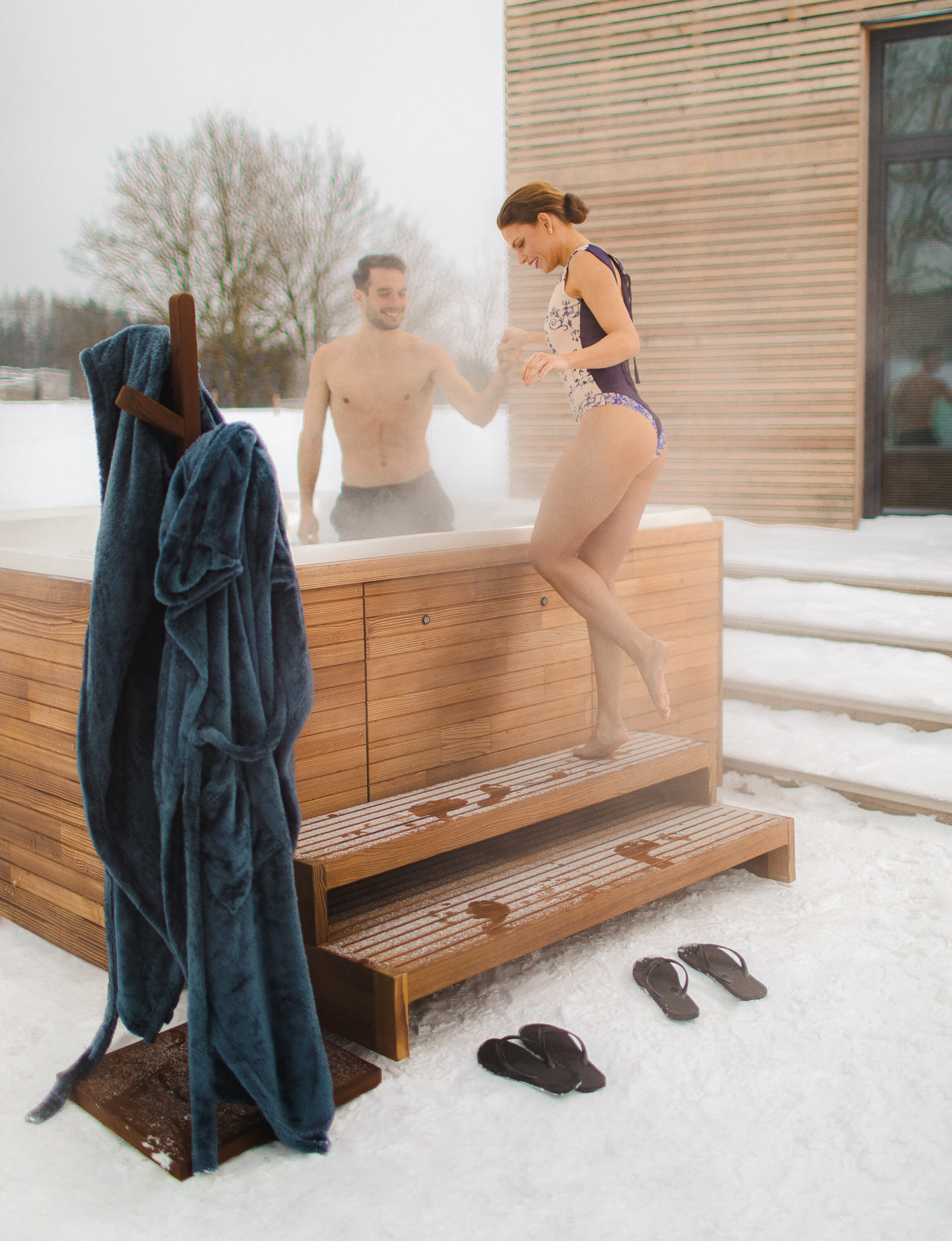 USSPA whirlpool with wooden accessories – hanger, steps, and woman entering the spa.